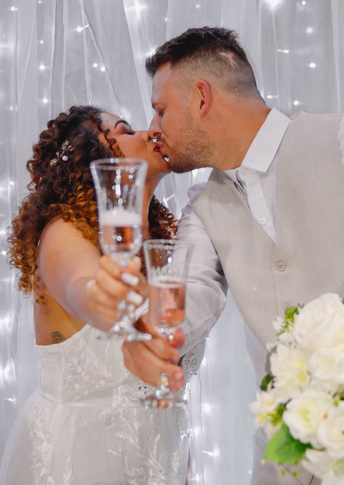 Alana e Cléverson brindando e beijando no casamento em São José dos Pinhais, PR.