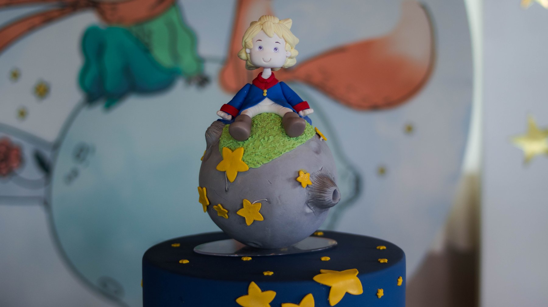 A vela do bolo do Pedrinho, que é o pequeno príncipe sentado na lua